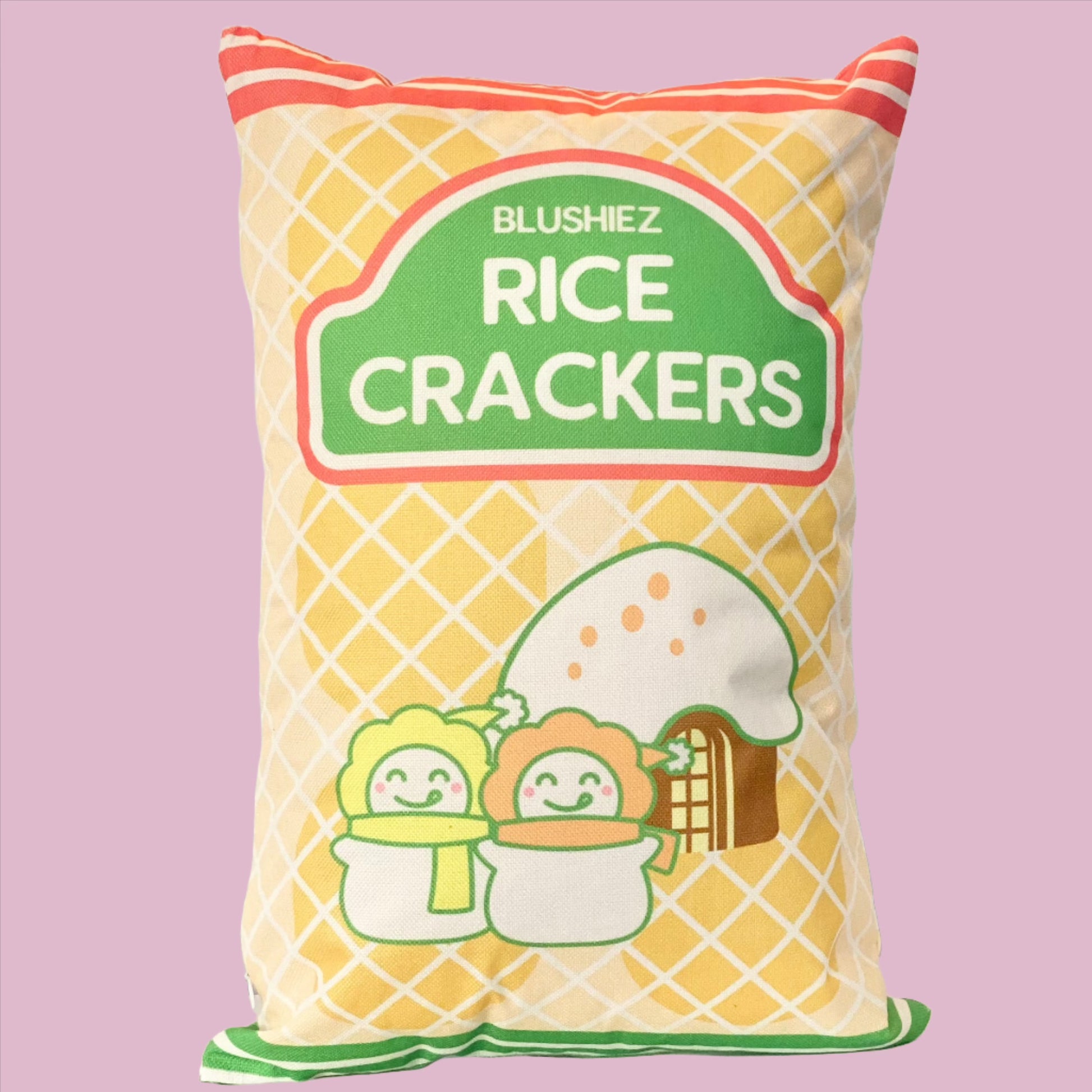 Pillow with a festive snack-inspired design. The pillow features a light orange background resembling rice crackers, with orange stripes at the top and green stripes at the bottom. The design includes a charming scene of two snowmen in front of a house with a snowy roof, evoking a festive and wintery atmosphere.